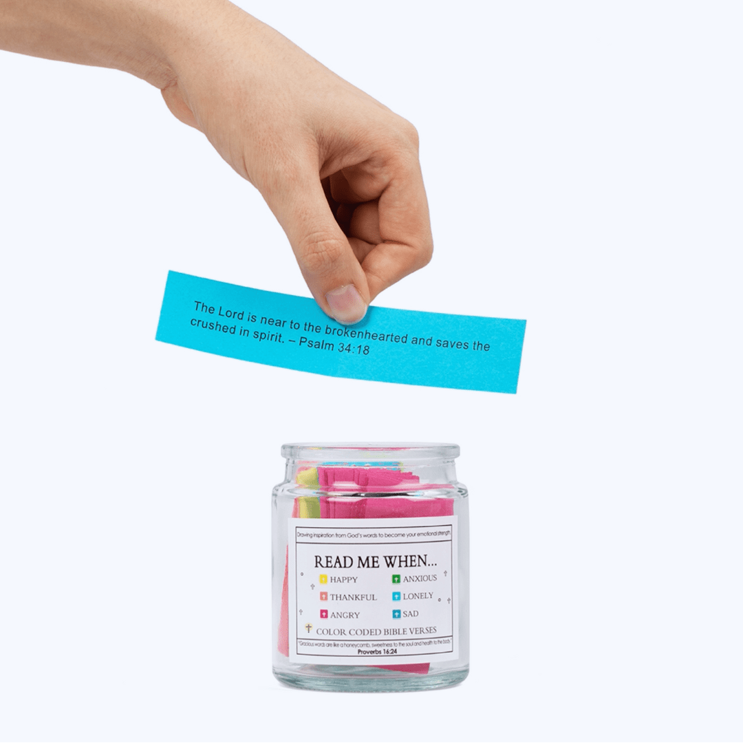 Hand placing a blue Bible verse card into the Bible Verse Jar