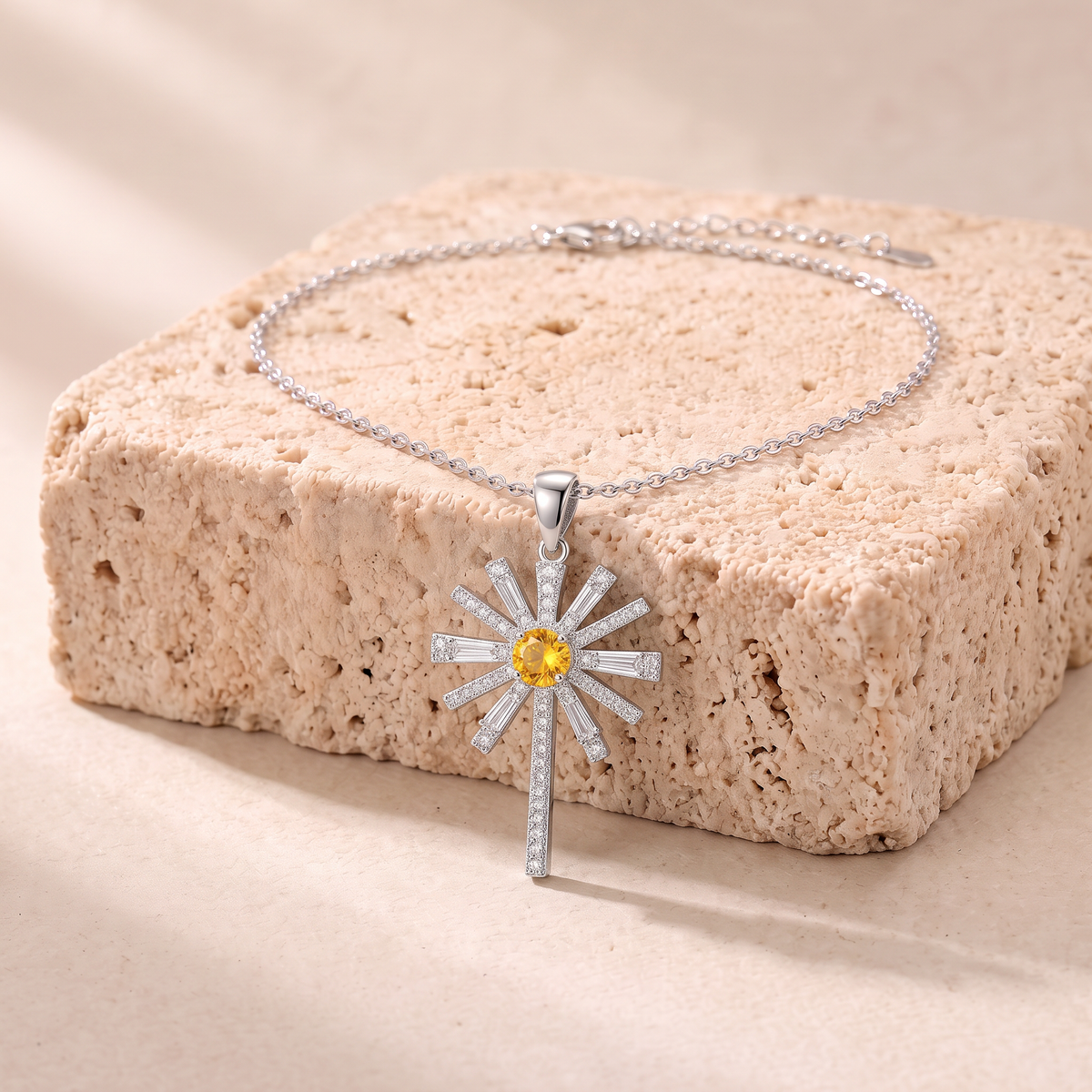Hannah yellow zircon sunburst cross necklace on travertine