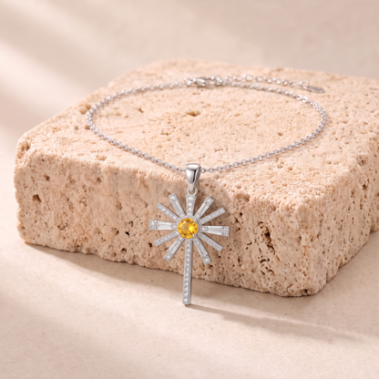 Hannah yellow zircon sunburst cross necklace on travertine